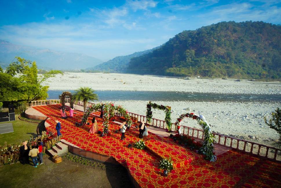 Luxury destination wedding venue in Jim Corbett with outdoor lawn setup and nature backdrop